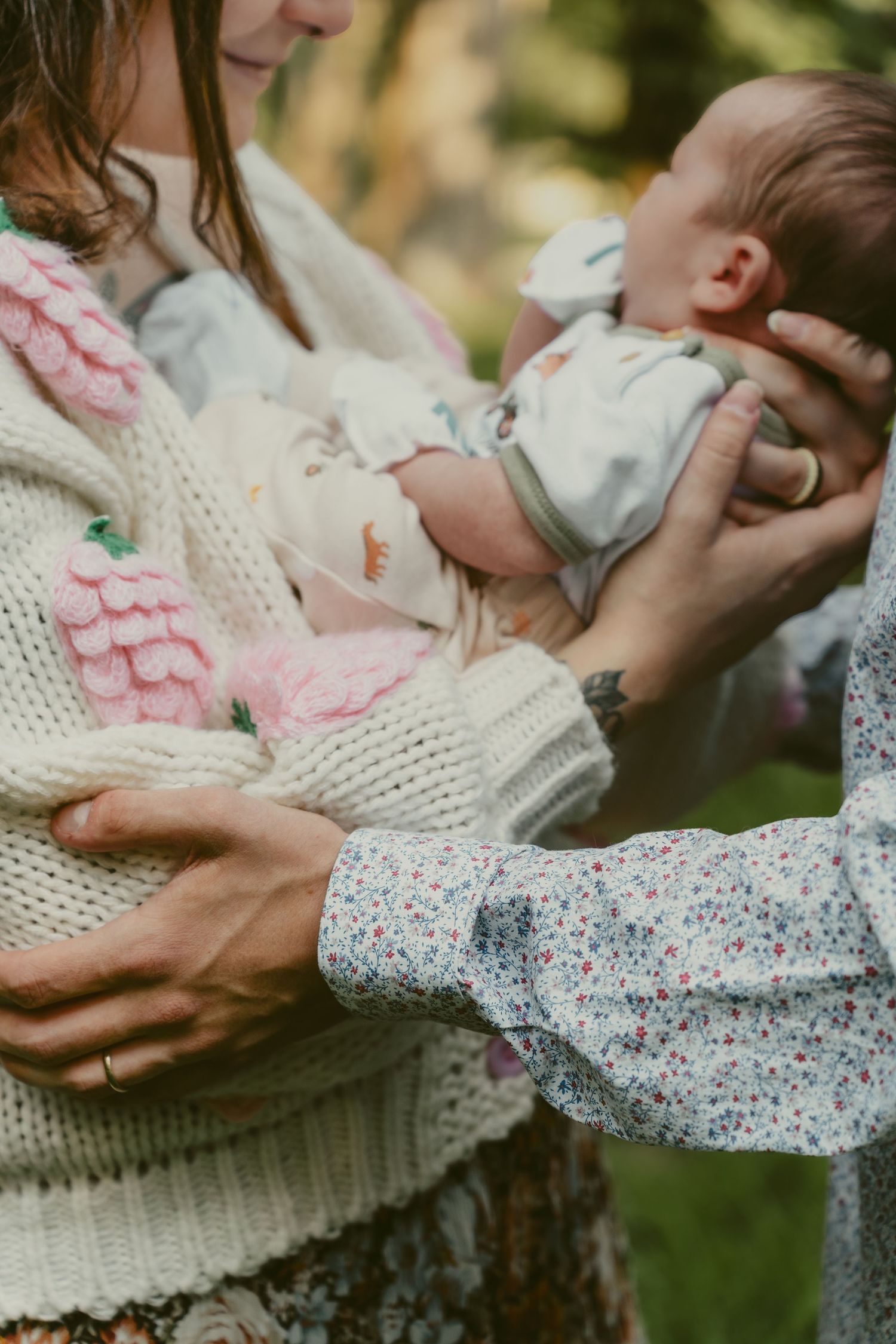 A close up photo during a family session of a mother and father holding their newborn baby at a park in Centerville Ohio.