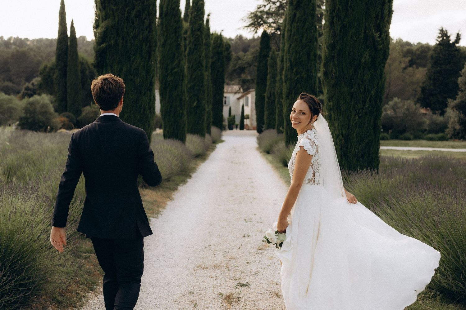 A romantic black and white wedding photograph showing a tender embrace in a natural outdoor setting.