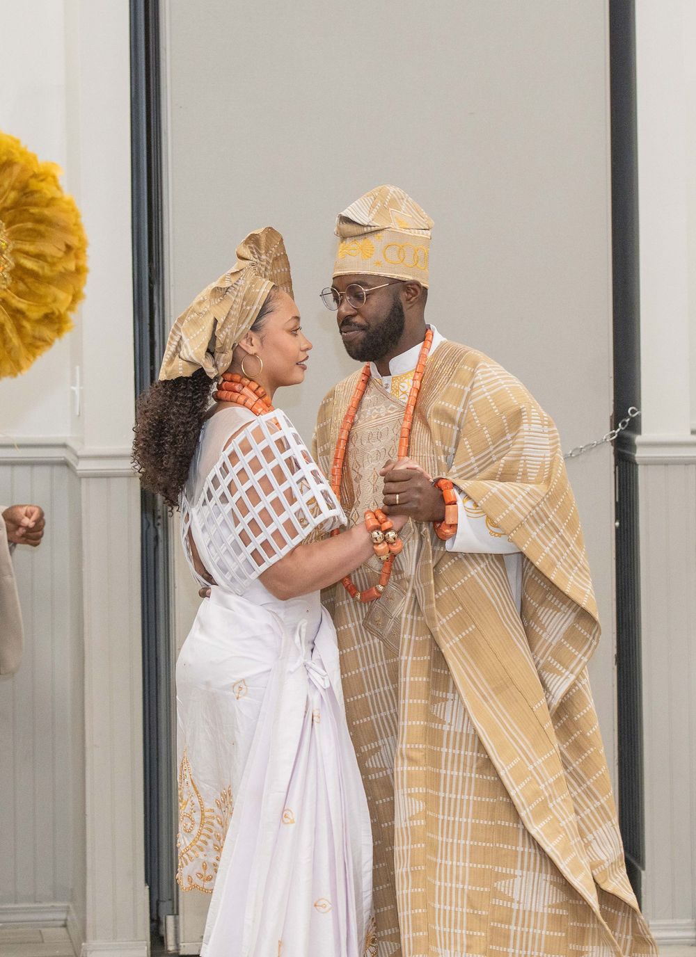 Two people in traditional African-inspired attire share a tender moment against a light-colored wall. Kelly Photography Atlanta