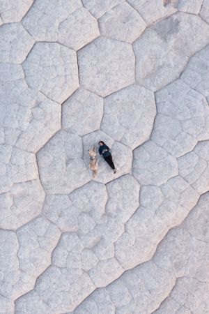 Cracked and weathered white salt flat surface texture with hexagonal patterns.