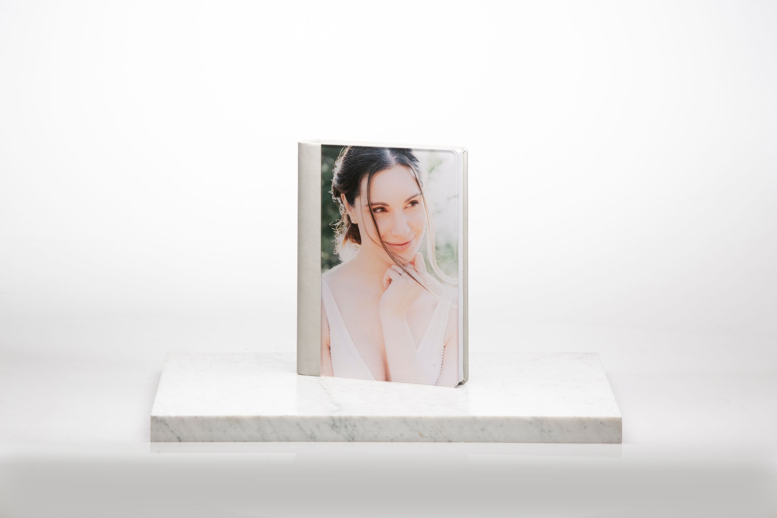 Photo in pastel tones displayed on minimalist white platform against light background.