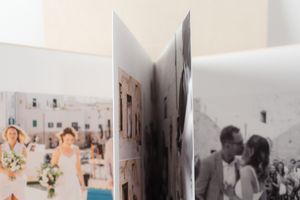 Open pages of wedding photo album showing vintage black and white and color photographs.
