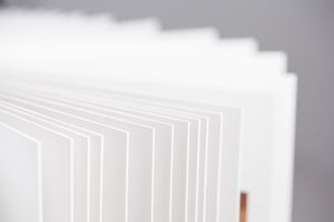 White architectural model with vertical slats and red accents shows a minimalist modern building design.