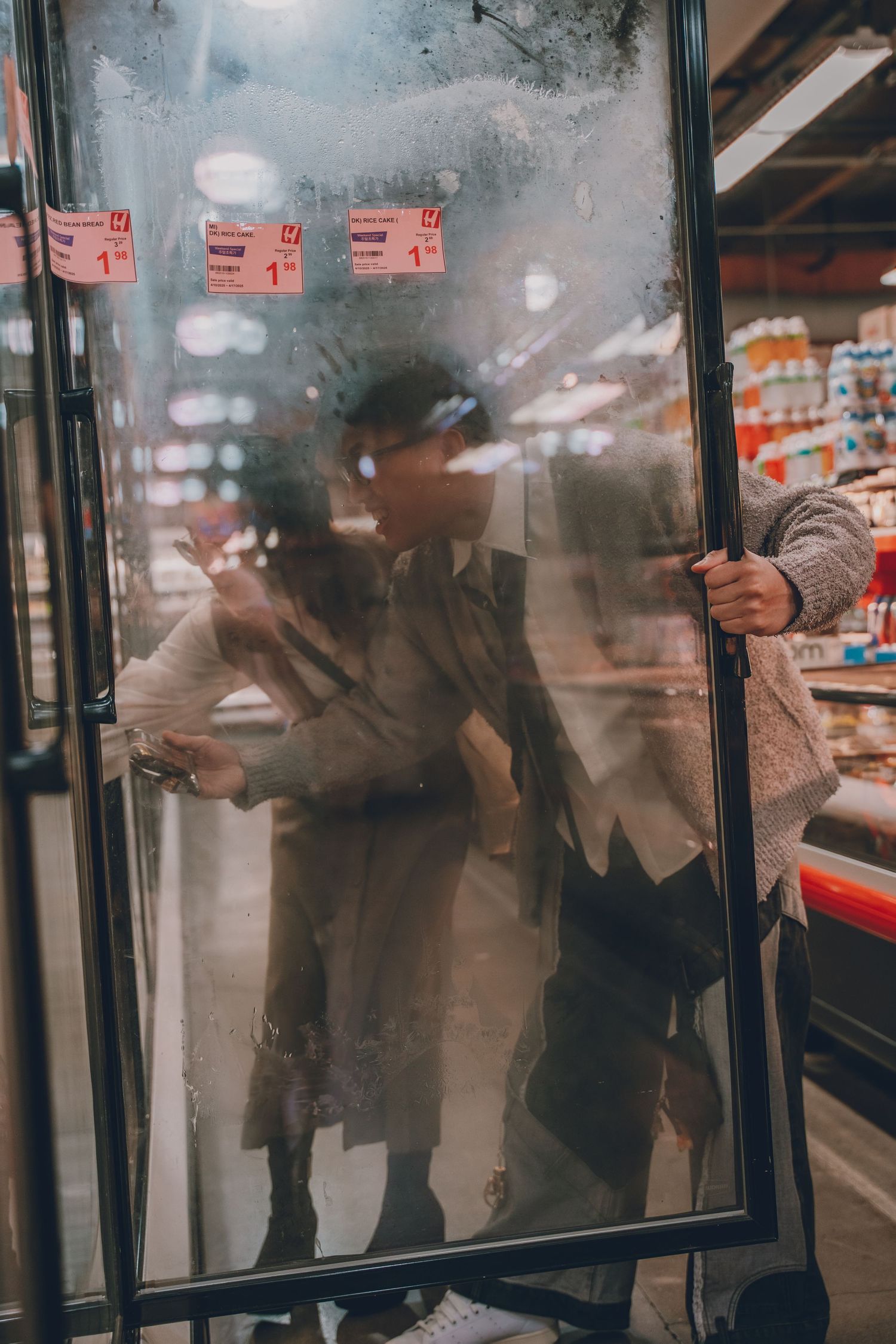 a photo of a man and woman looking through a freezer