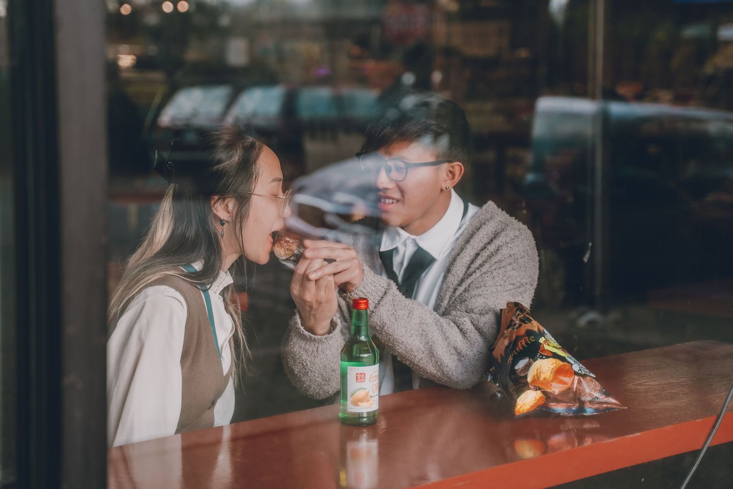 a man feeds his girlfriend a musubi in this fun couples photography shoot