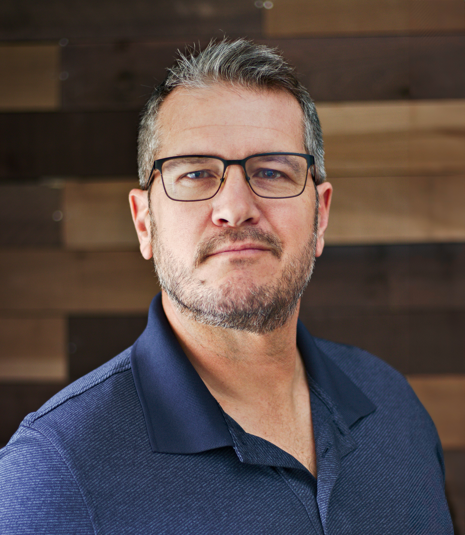 Professional business portrait with wood paneled background.