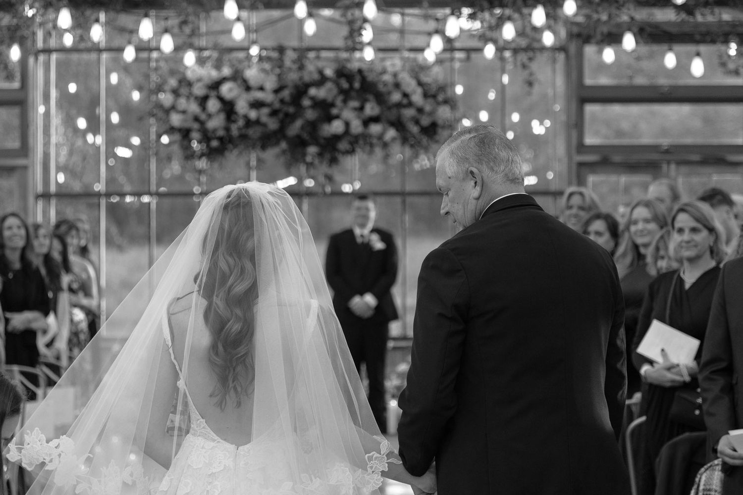 Candid emotional wedding ceremony aisle moment as bride walks with her father down the isle, captured by Cleveland wedding photographer.