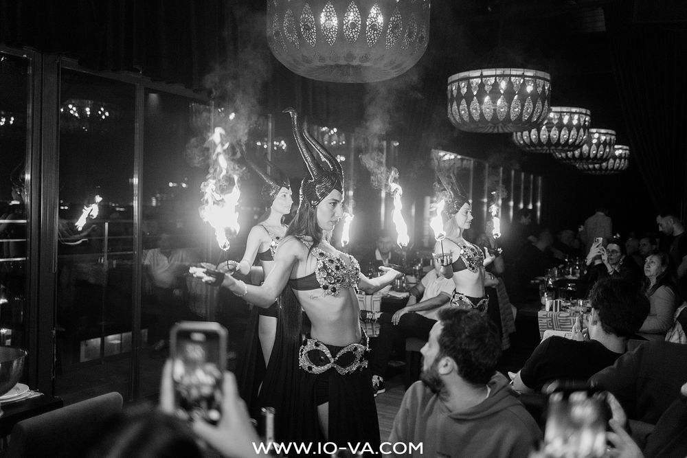Belly dancers perform with fire during a lively dinner show in a dimly lit Istanbul restaurant.
