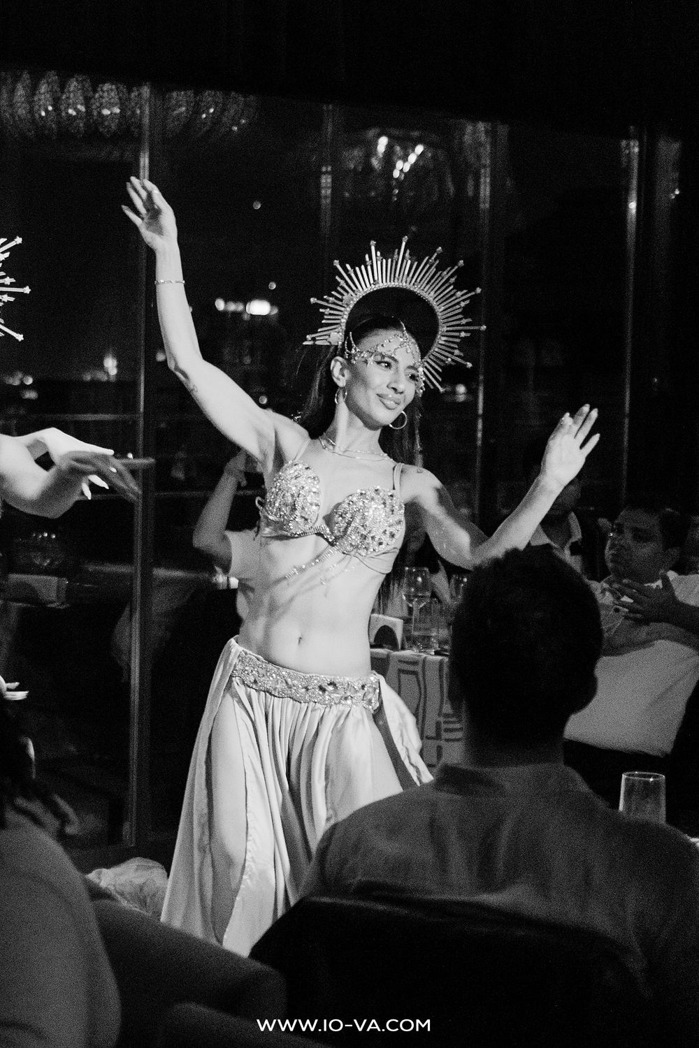 A belly dancer in ornate costume performs with a sunburst crown at an Istanbul dinner show.