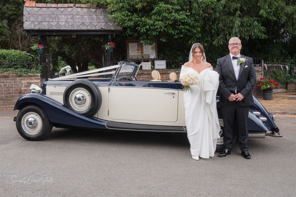 Vintage luxury wedding car parked outside St Peters Church in Cookley, during a wedding celebration with the bride & father of the bride.