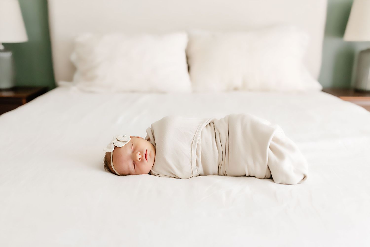 A peaceful white bedroom setting with plush bedding, pillows, and natural light creating a serene atmosphere.