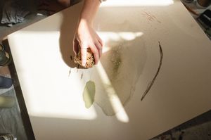 A white paper notepad reflects shadows cast by bright overhead lighting and nearby objects.