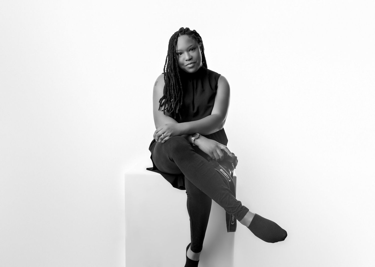 Black female Photographer Vanessa Charlotte in black and white fashion photos wearing black outfit. with canon camera in Wolverhampton