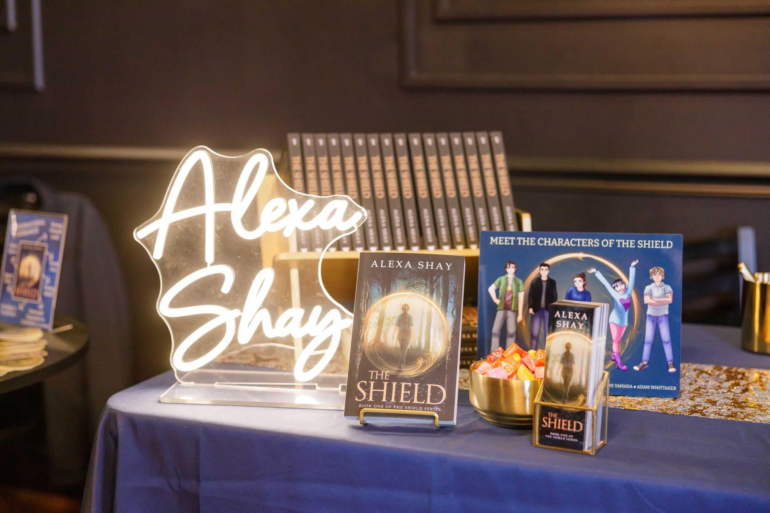 indie book author Alexa Shay author signing event in Seattle, WA bookstore table display of books, swag, character art and light sign
