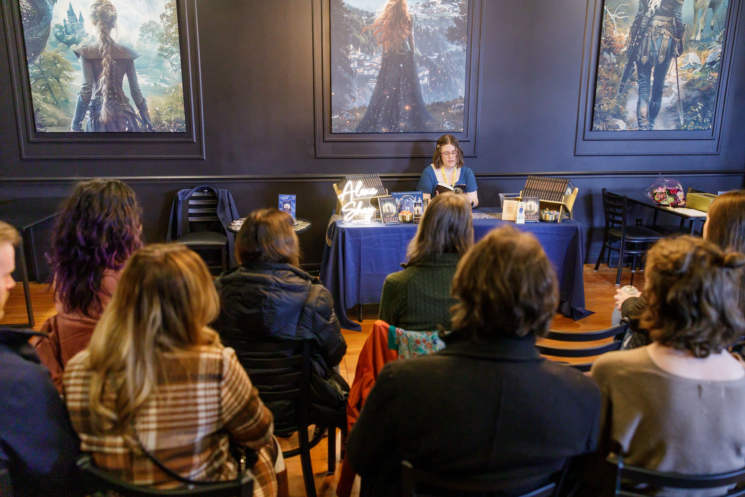 indie book author Alexa Shay author signing event in Seattle, WA bookstore sitting reading to readers in audience
