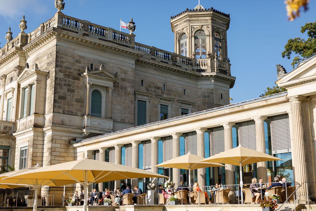 Grand baroque palace exterior with yellow umbrellas and classic architectural details. Organized wedding by MyCastleWedding | Dresden.