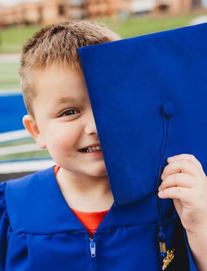 kindergarten cap and gown boy blue cap and gown football field