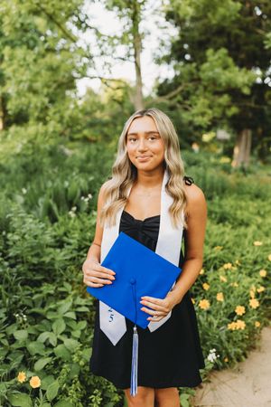 senior girl black dress blue cap and gown