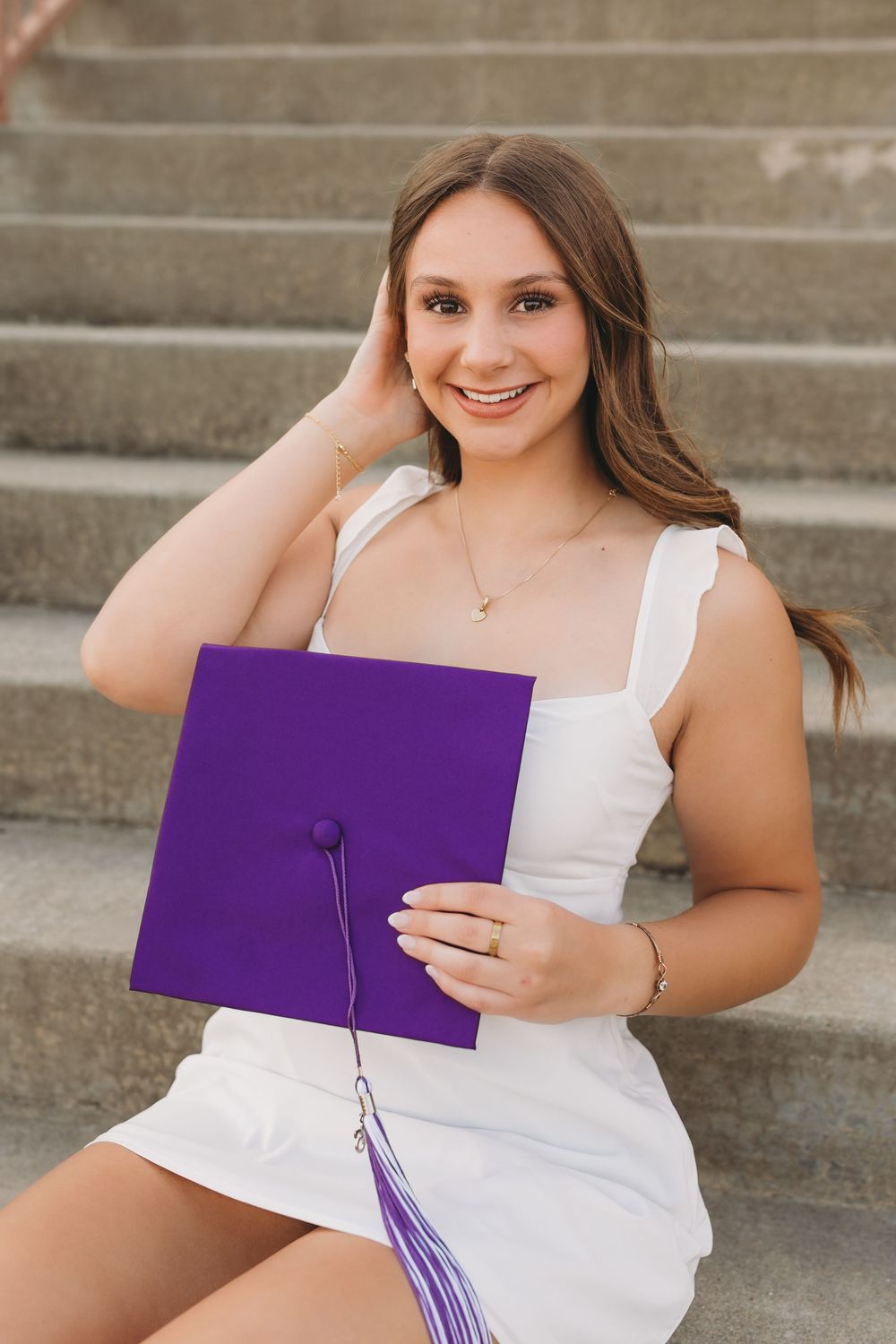 Graduate senior girl white dress purple cap and tassel