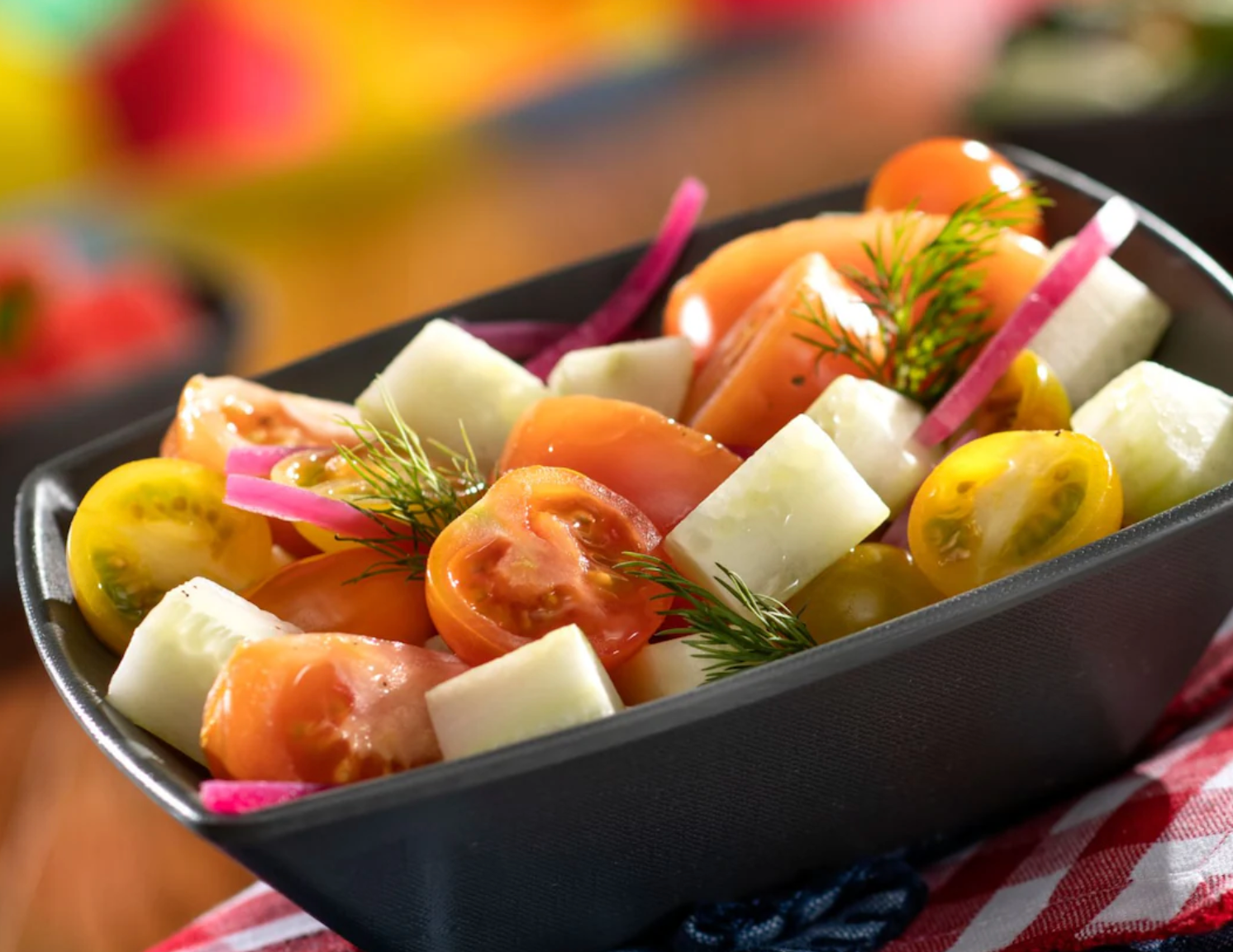 Colorful appetizers and canapes arranged in black serving dishes with garnishes.