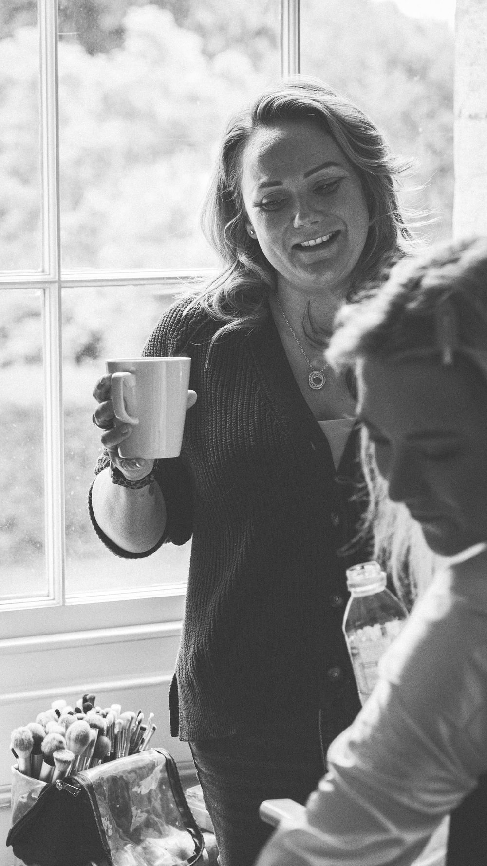 A series of four black and white progressive photos showing someone joyfully dancing while holding a coffee cup.