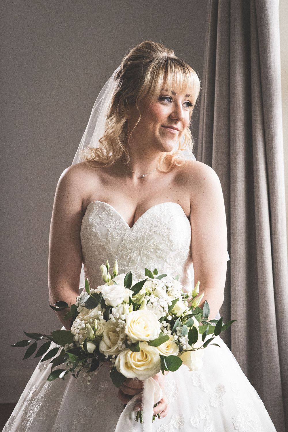 Series of elegant bridal portraits showing a white wedding dress and cream rose bouquet near a window.