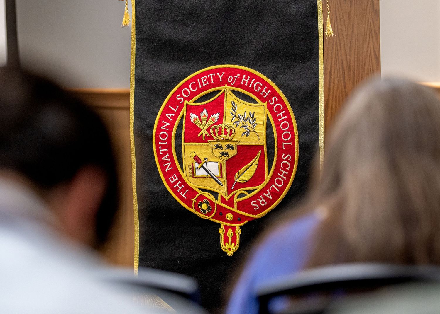 Red and gold university seal emblem displayed on dark banner.
