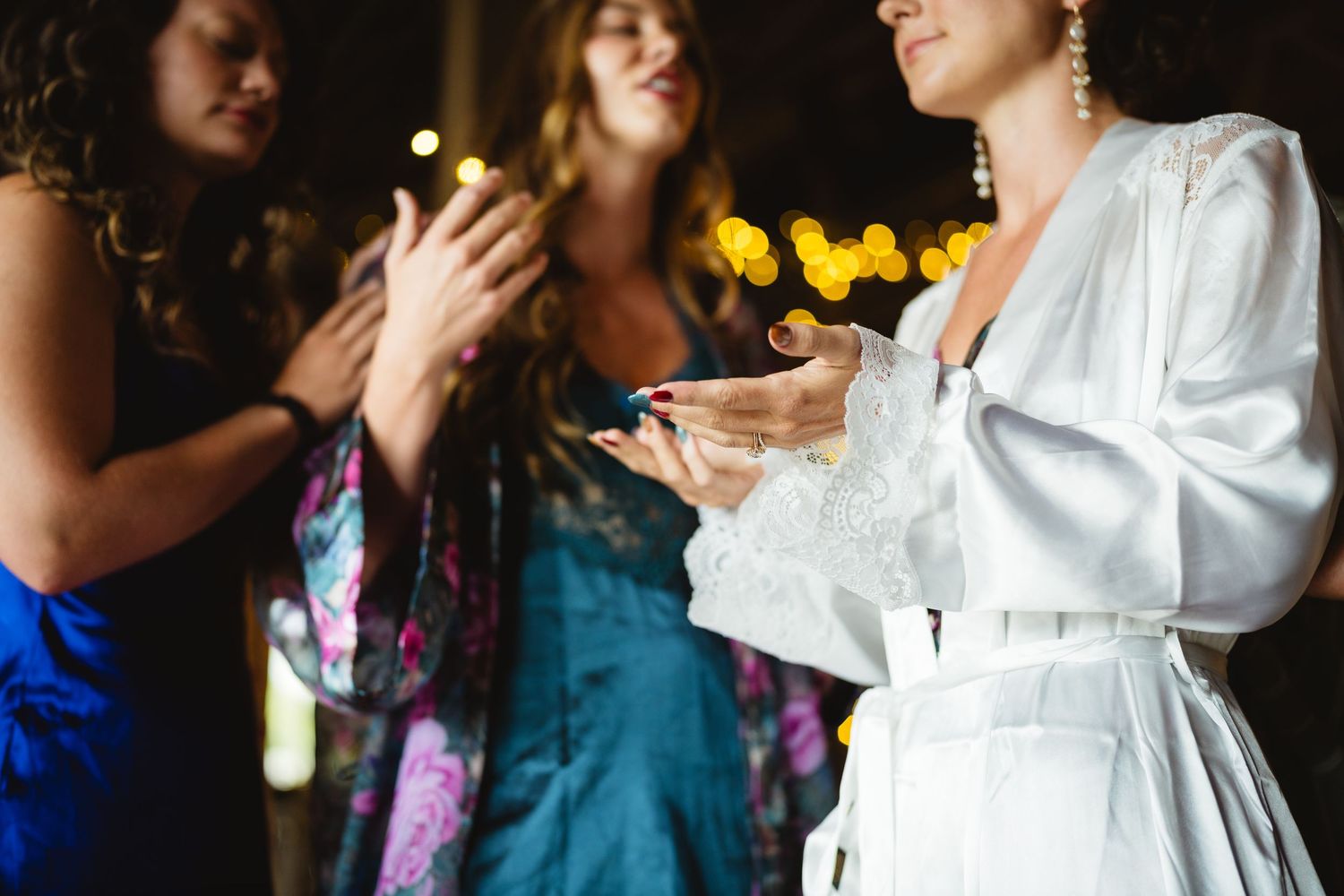People in colorful dresses and white robe gather at a celebration with sunflowers in the background.