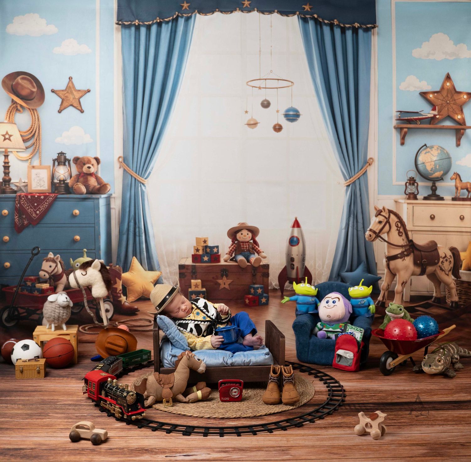 Toy Story themed nursery photo with baby surrounded by colorful toys, plush animals in a playful room. At The Affinity Studio