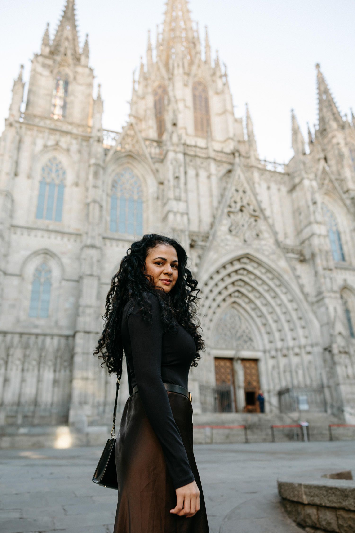 Gothic cathedral with ornate white spires provides dramatic backdrop for fashion photography.