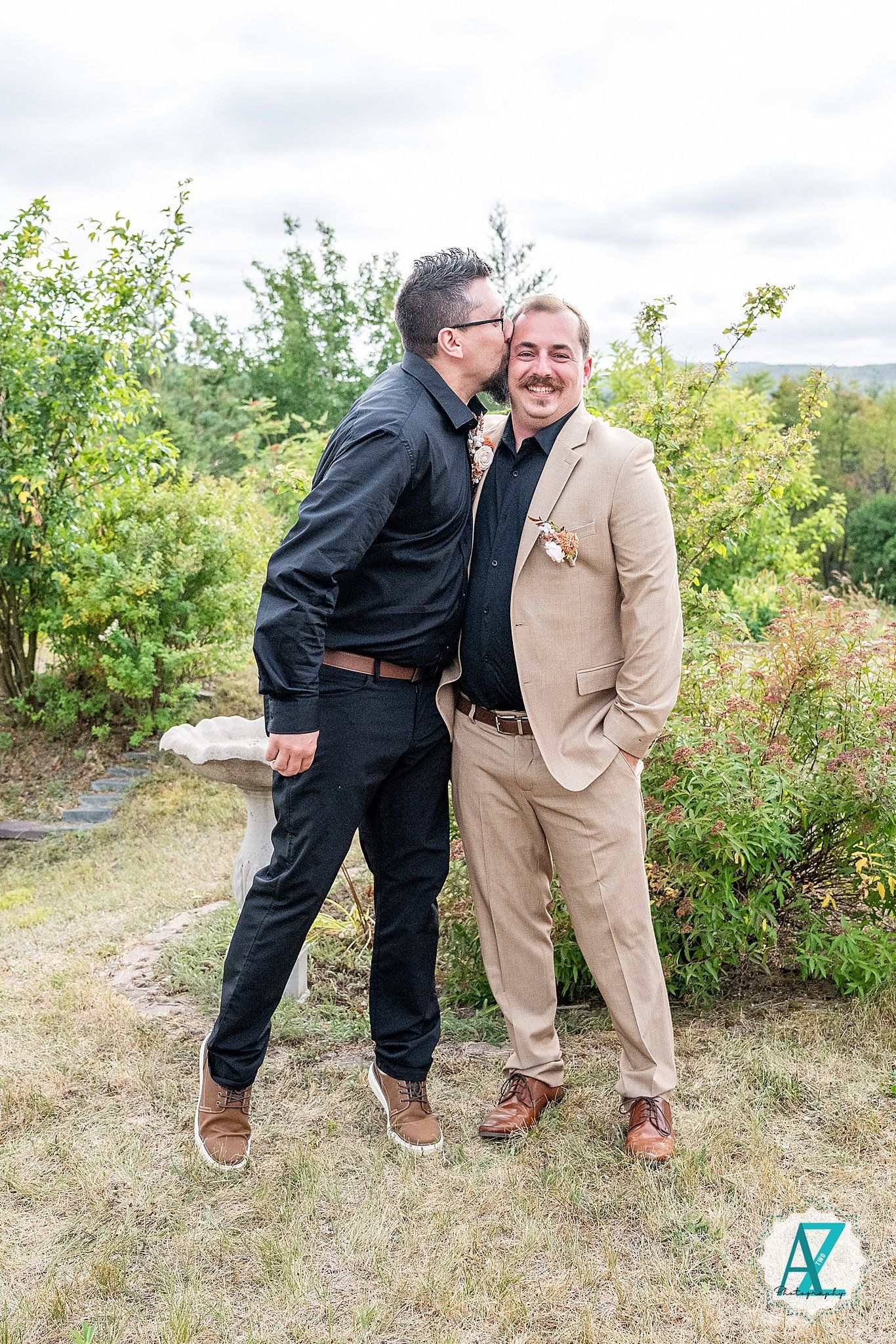 Wedding party members sharing candid moments on a natural hillside setting.