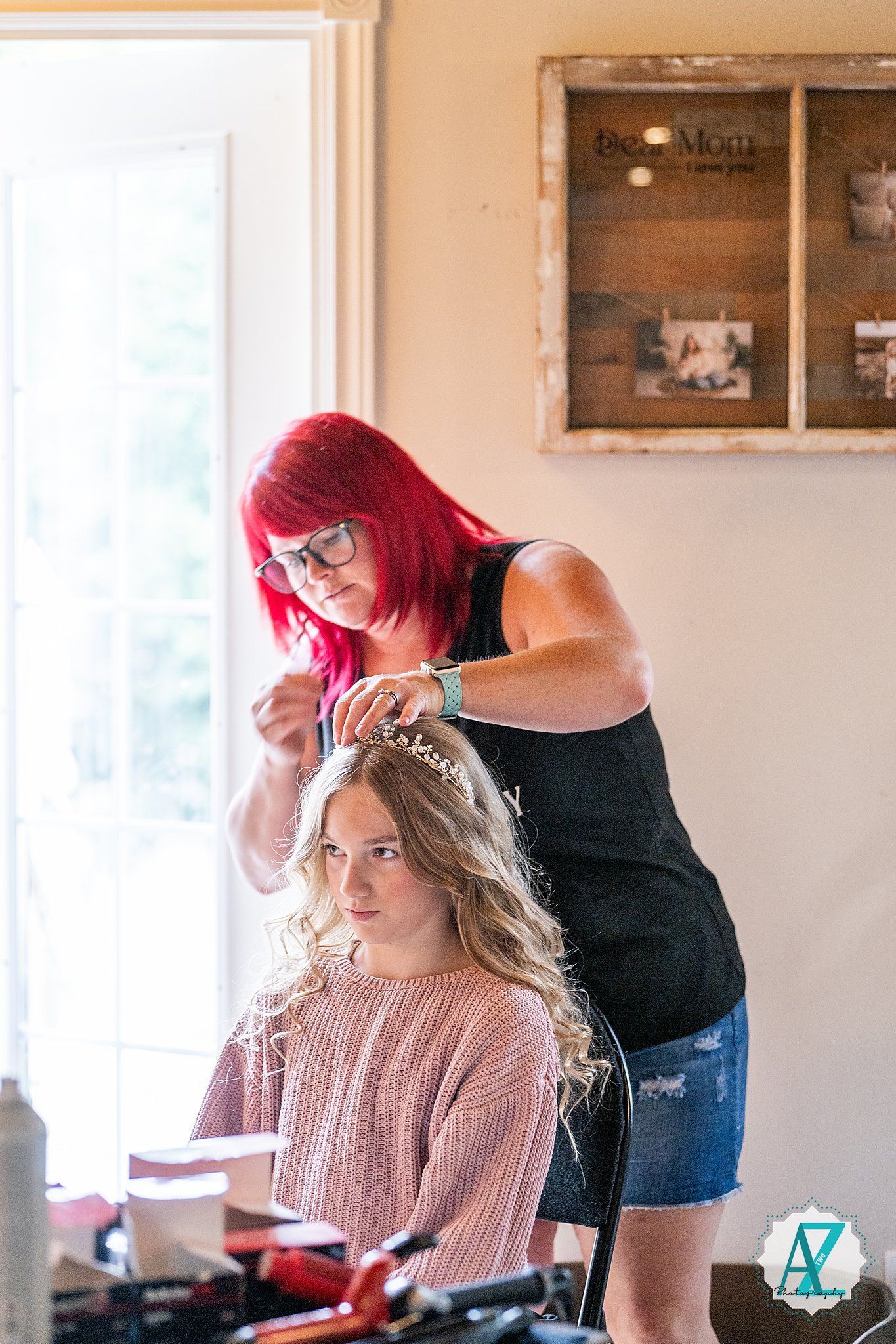 Hair styling session in progress with bright pink-haired stylist working on bride's updo.