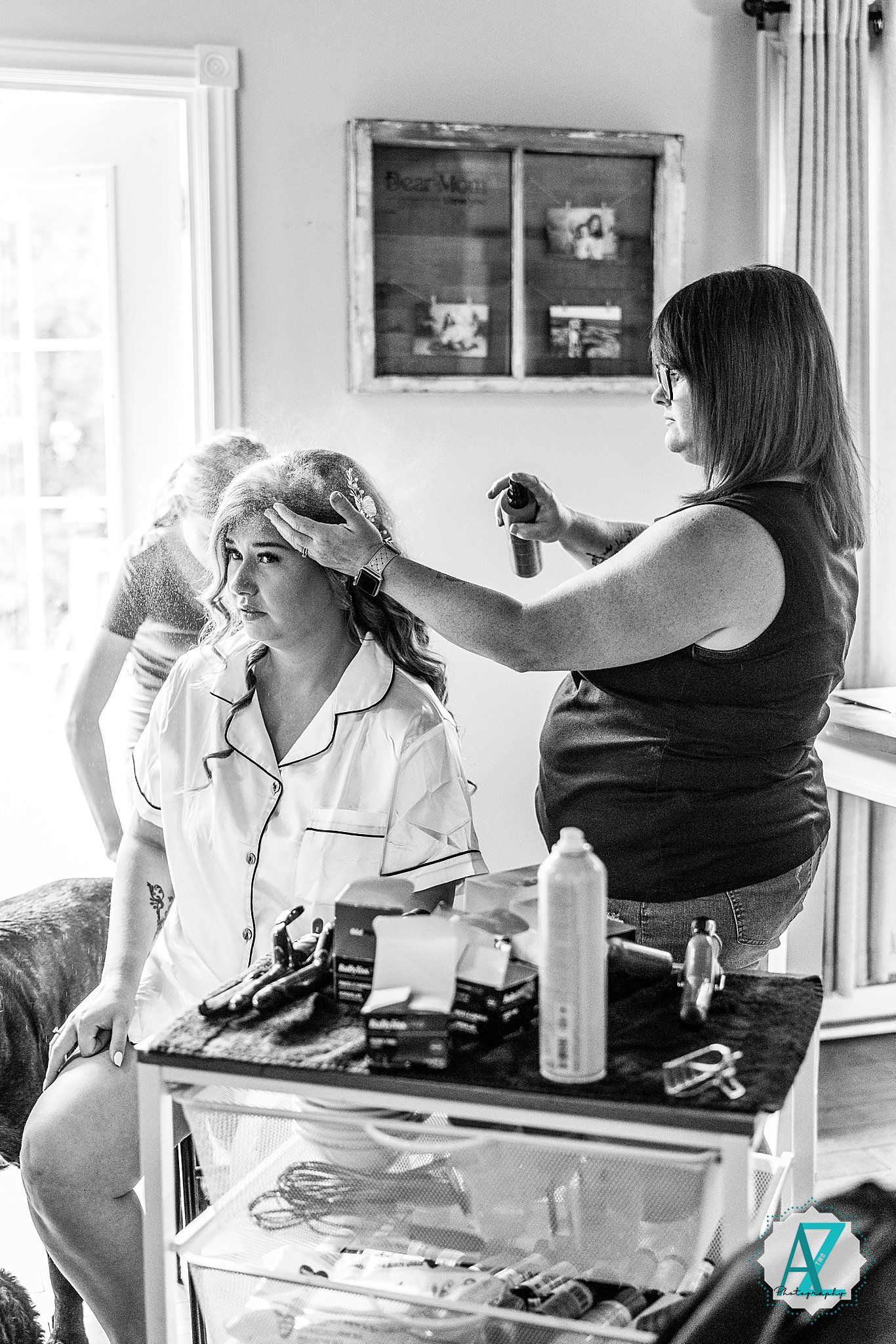 Three black and white photos show people preparing for a photoshoot in a bright studio with natural lighting.