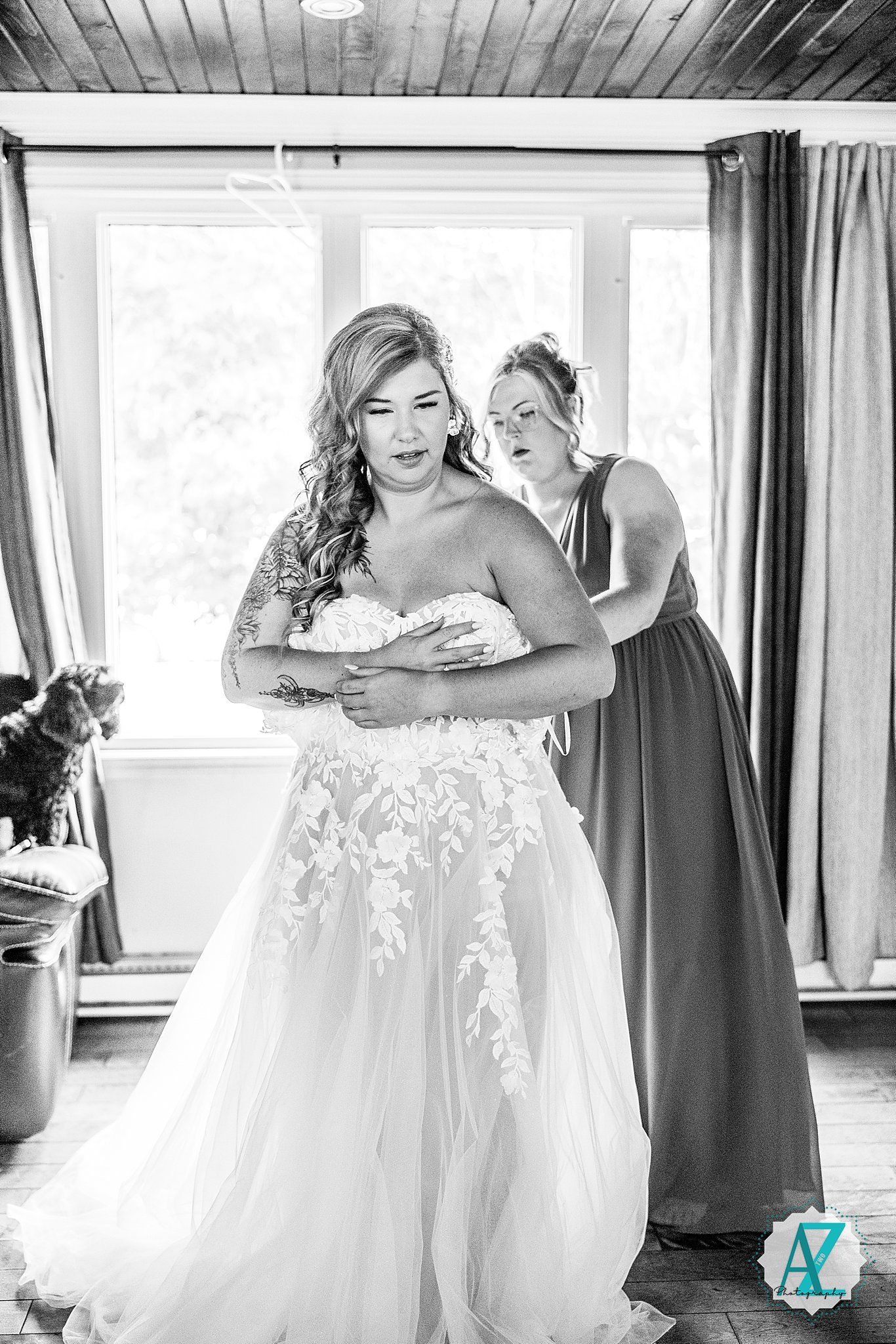 Black and white photos capture intimate moments of wedding dress preparation and adjustments.
