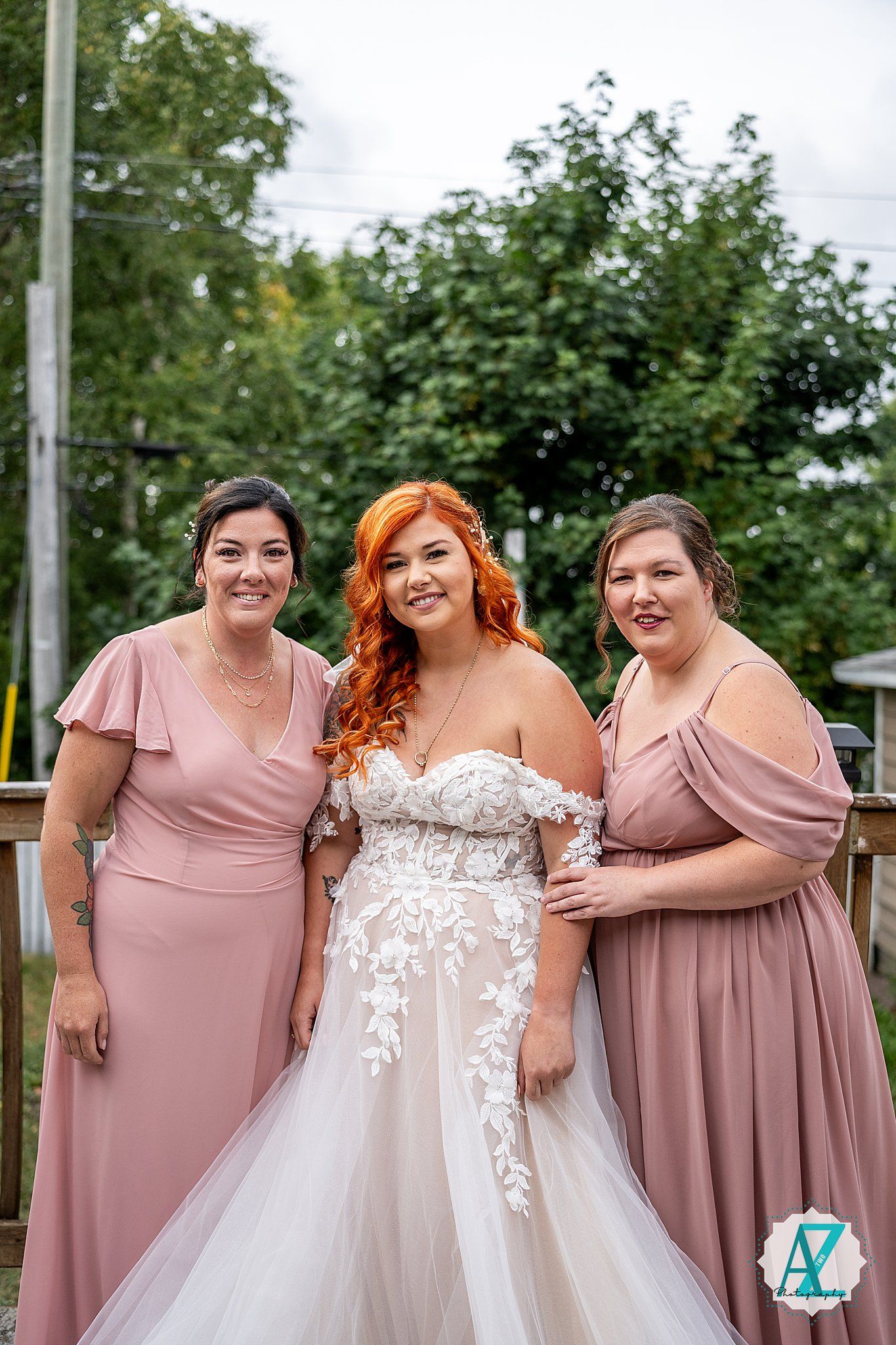 Bridal party poses together in mauve bridesmaid dresses and white wedding gown.