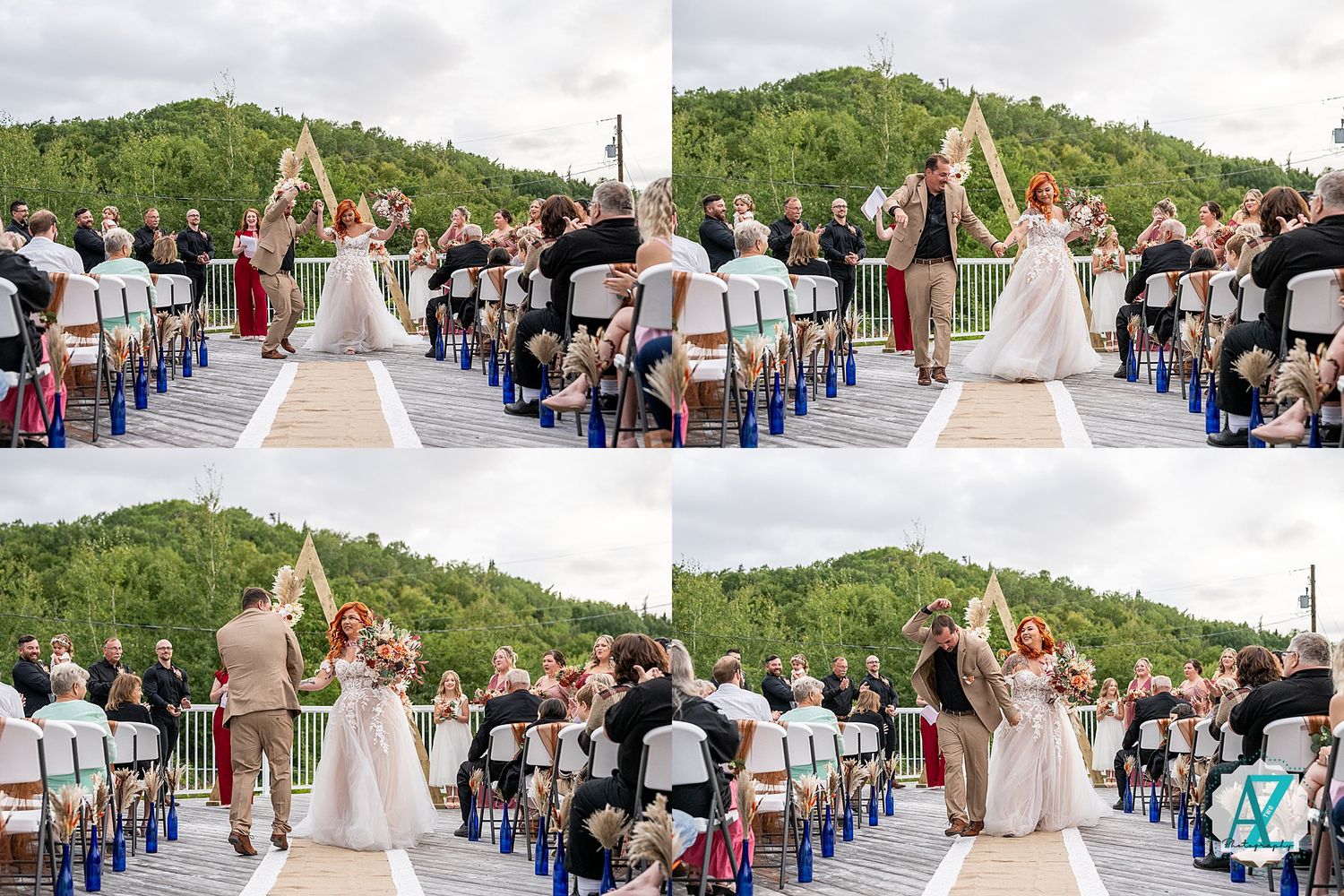 Large wedding gathering on outdoor deck with mountain scenery and white ceremony decor.