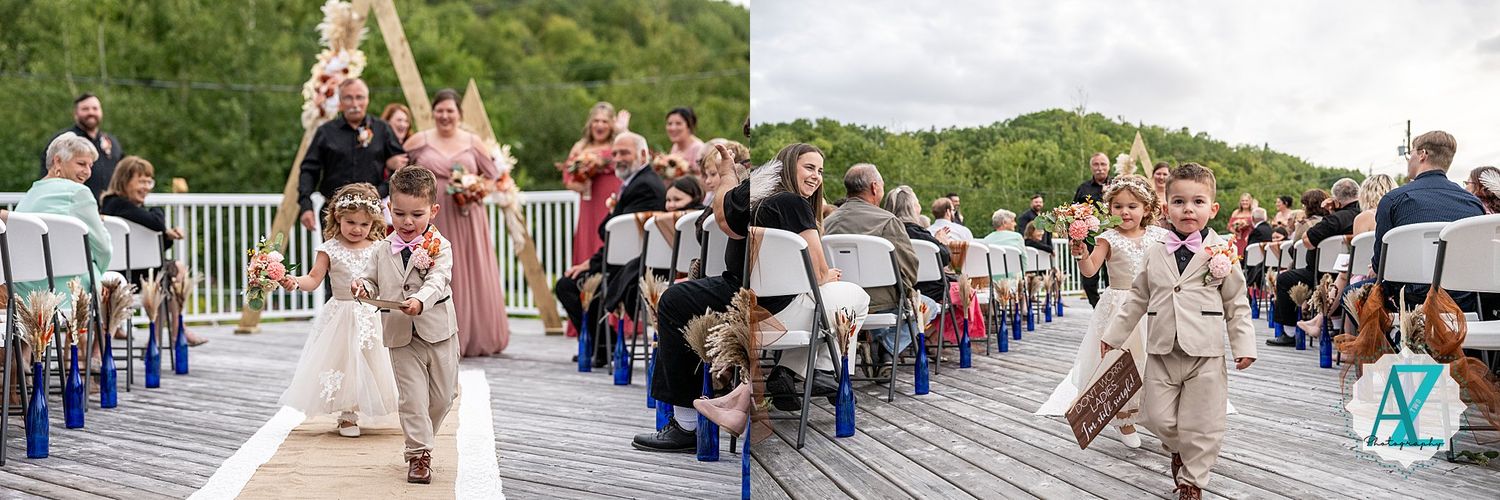 Wedding guests seated in rows of white chairs on a wooden deck with mountain views.