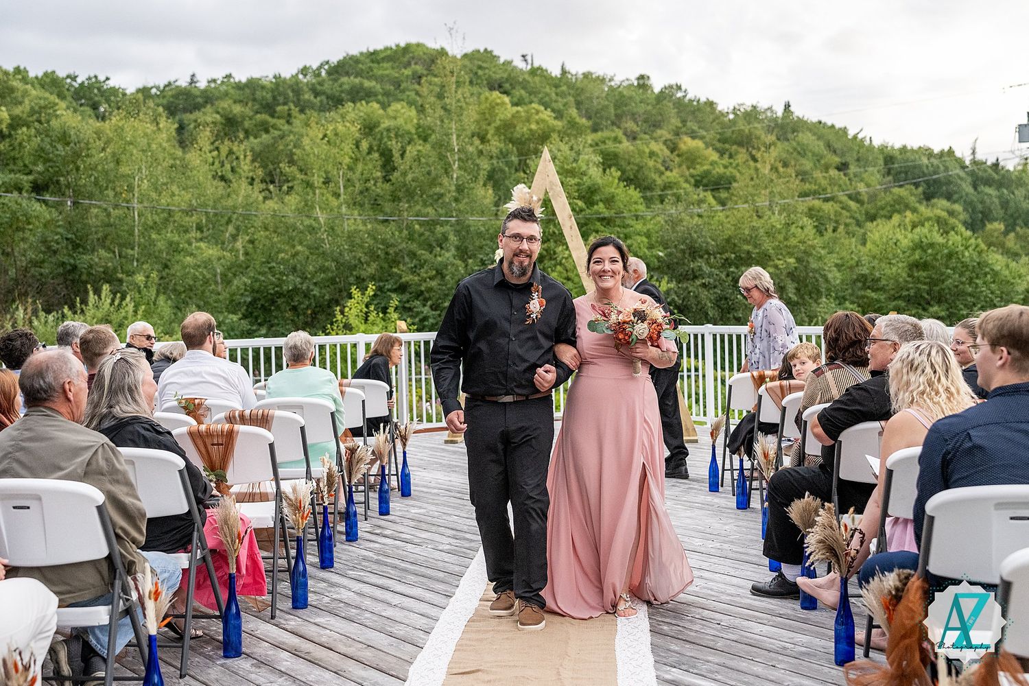 Outdoor wedding ceremony venue with rows of white chairs overlooking scenic mountain landscape.