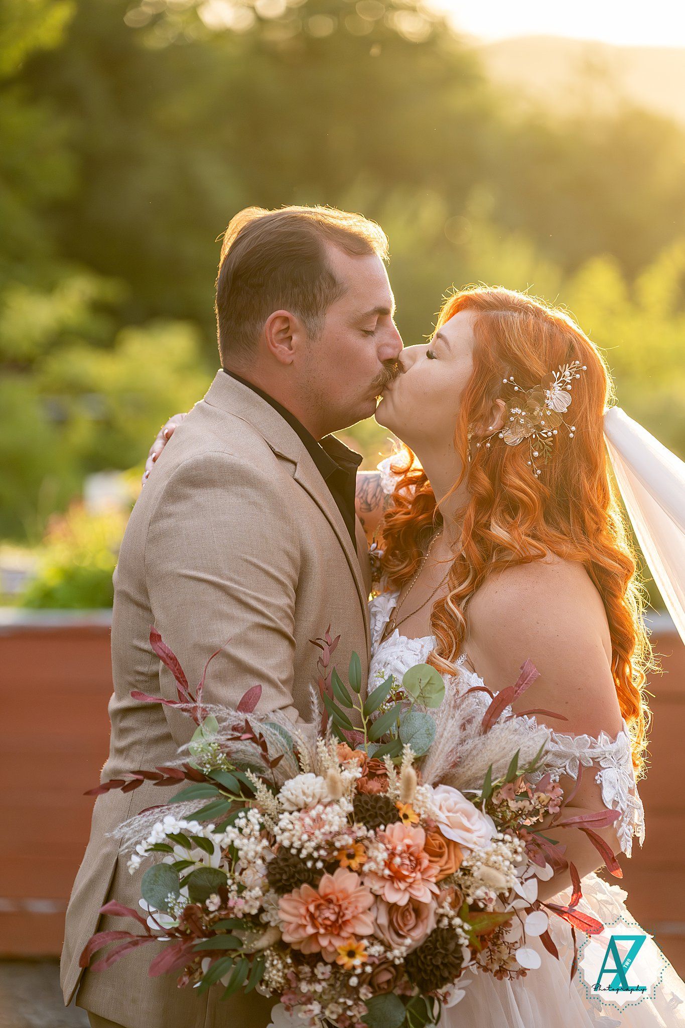 Wedding portrait at sunset showing couple with romantic floral bouquet and warm golden light.