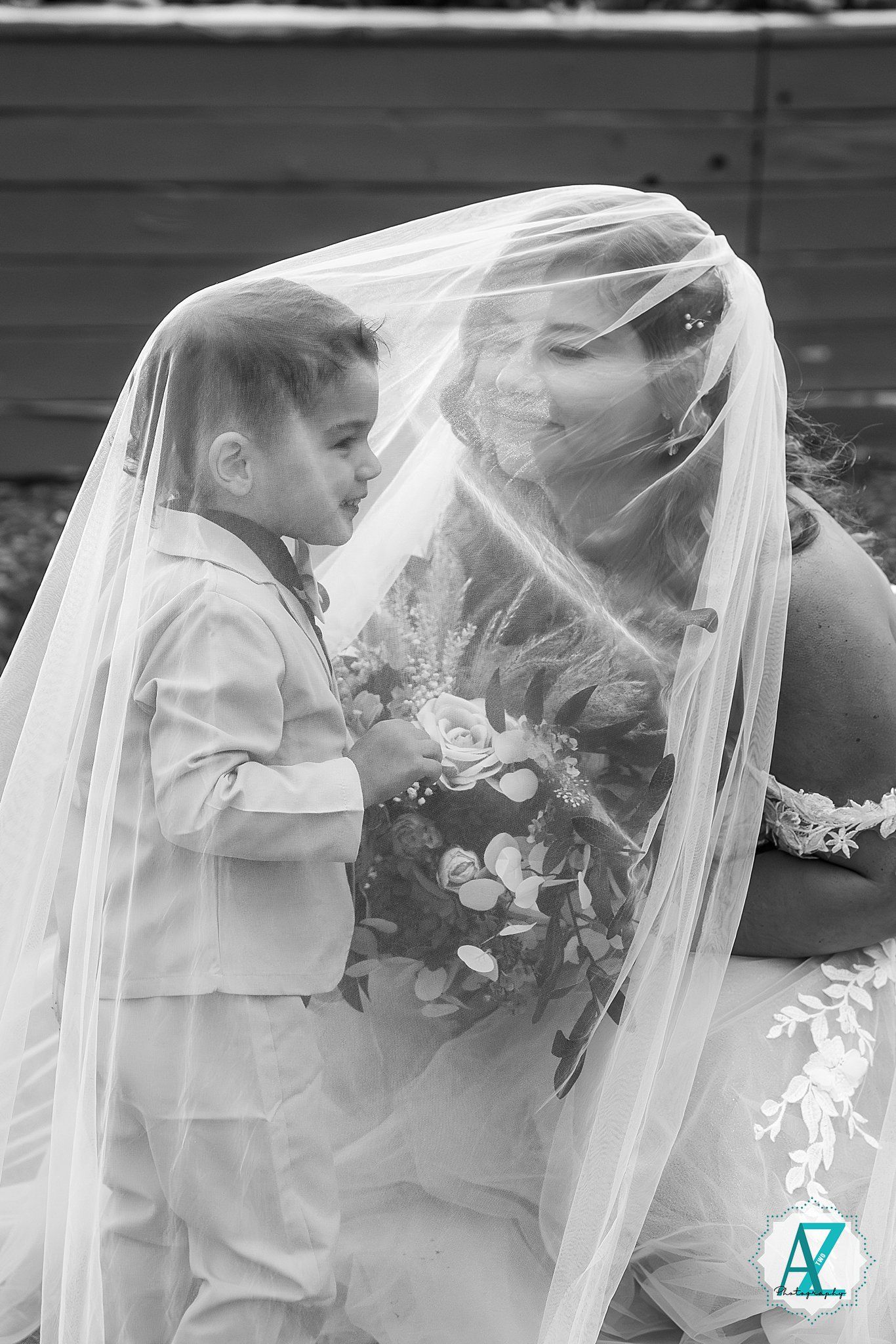Black and white artistic wedding portrait through a delicate tulle veil capturing an intimate moment.