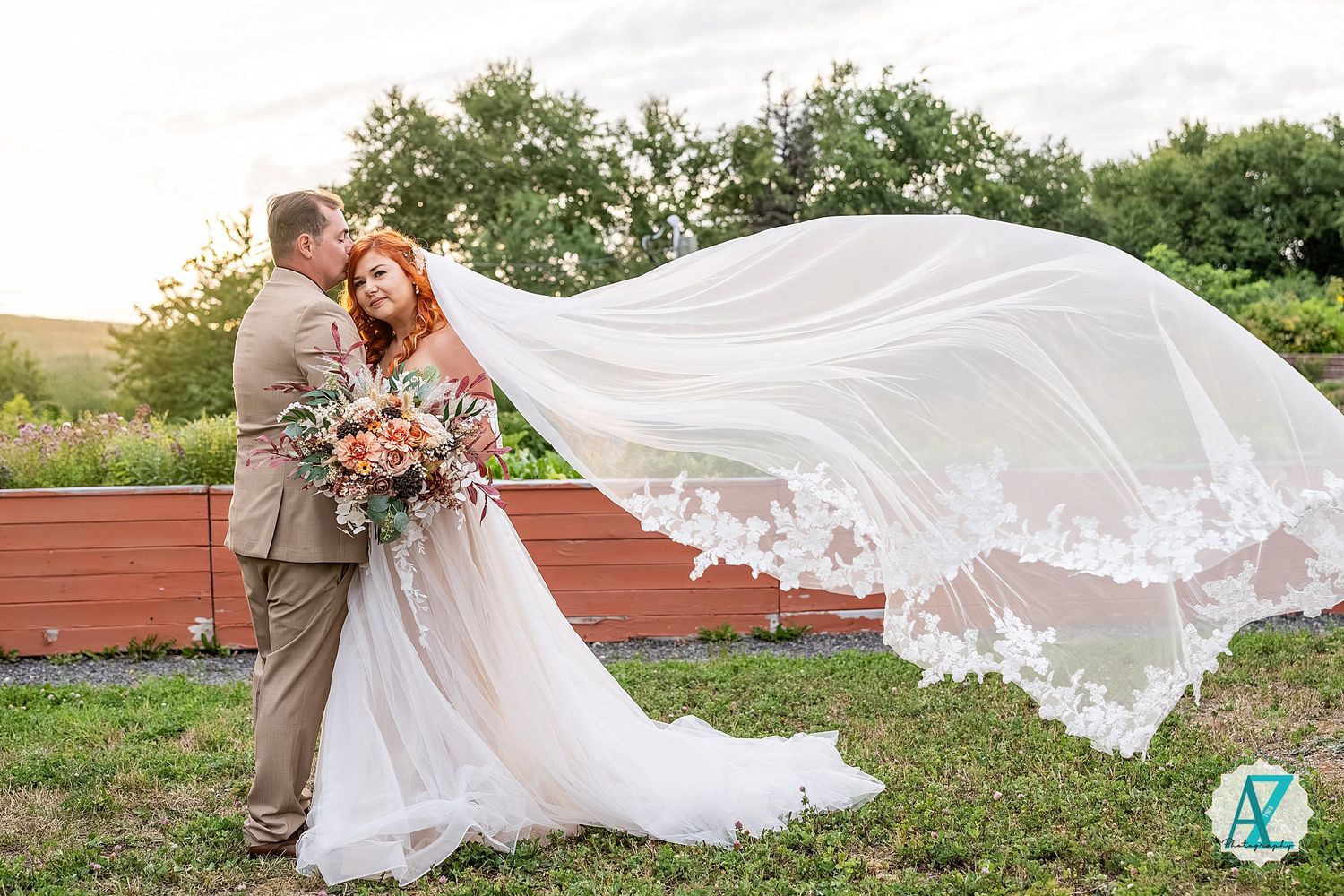 Wedding dress and veil flow gracefully in breeze during outdoor photoshoot.