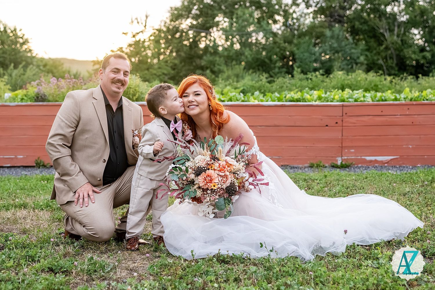 Wedding party enjoying candid moments in lush garden setting at sunset.