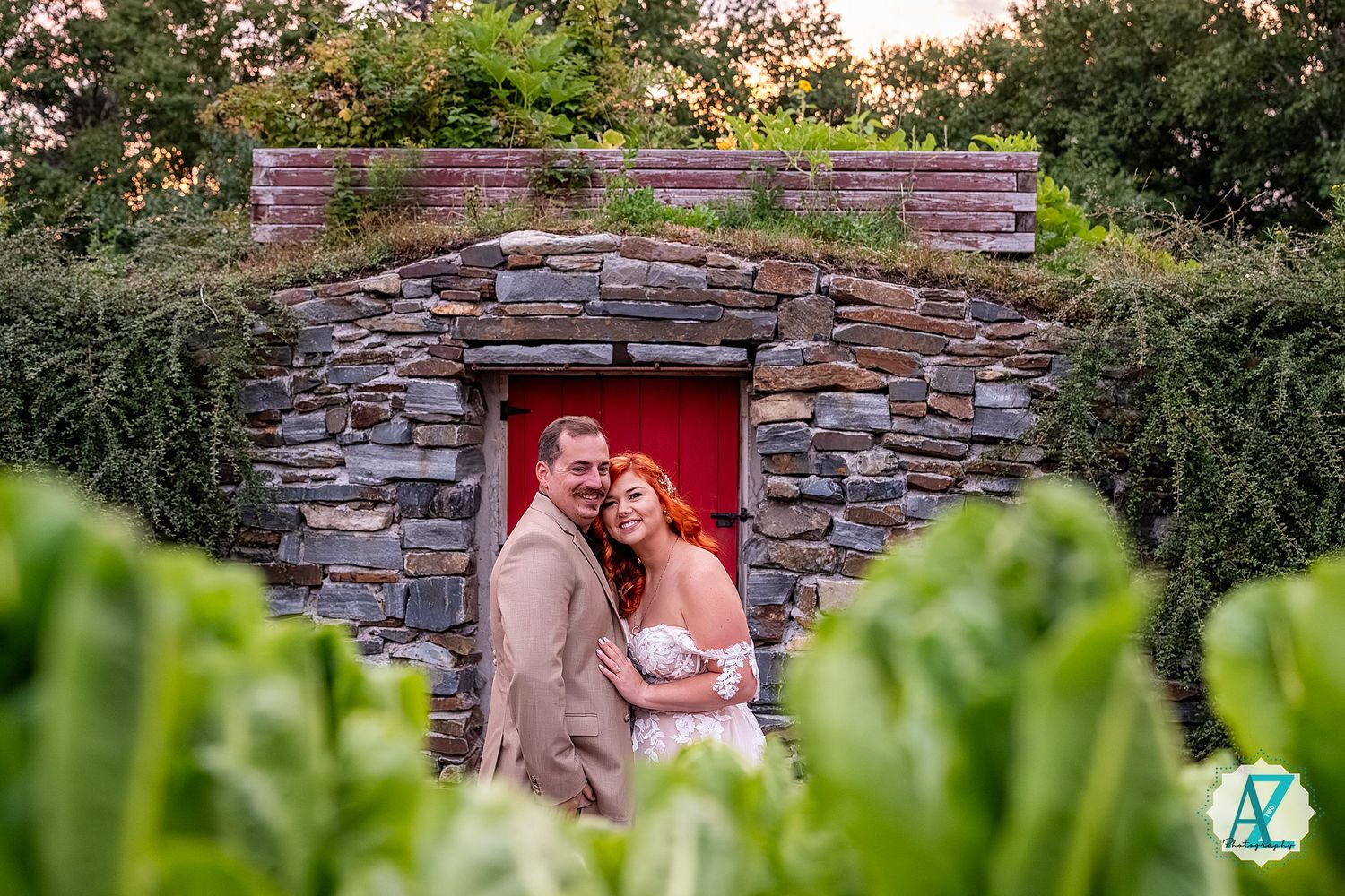 Stone wall surrounded by lush greenery creates romantic backdrop at sunset during outdoor photography session.