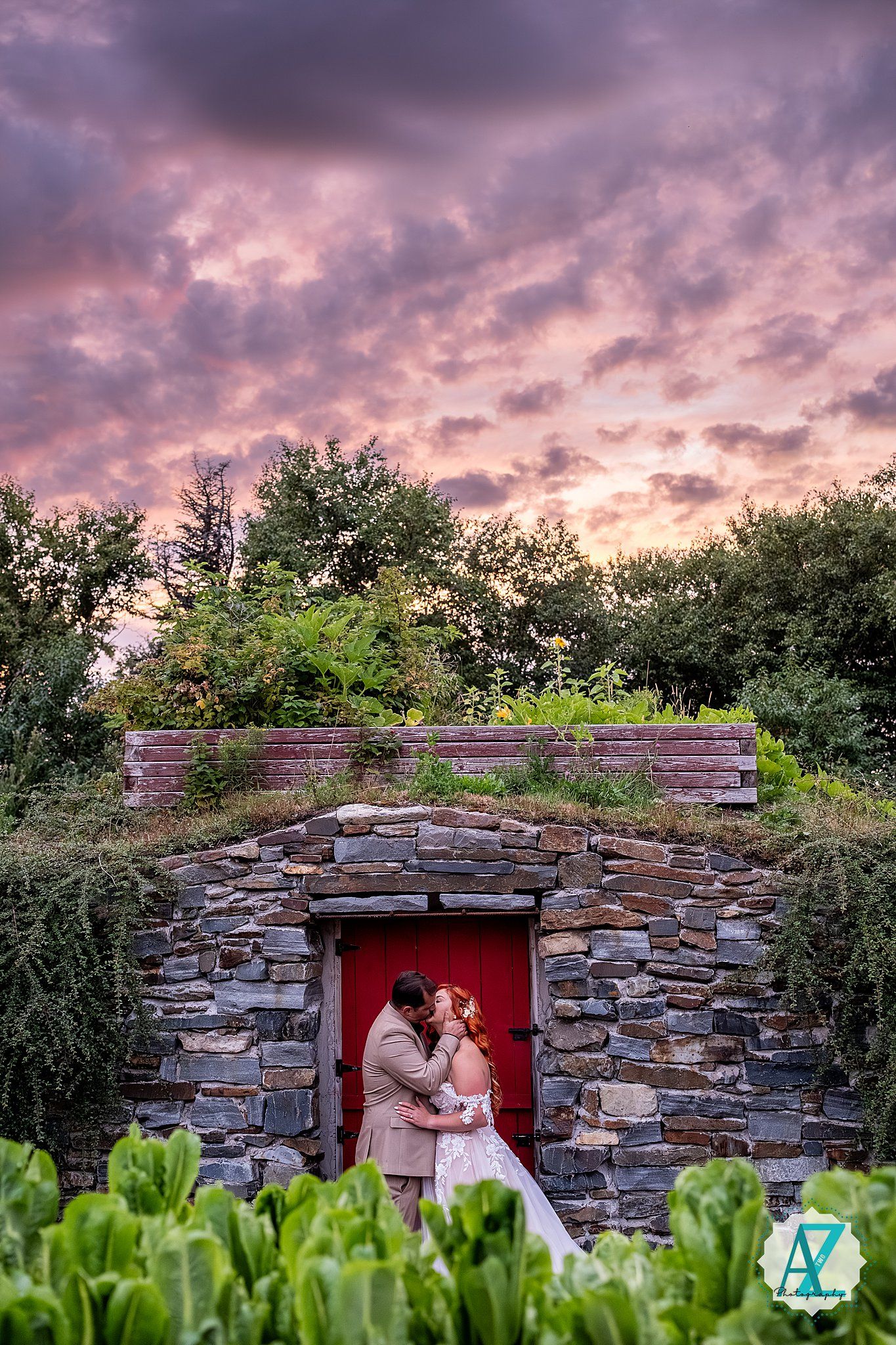 Stone wall with red door creates rustic backdrop under dramatic purple sunset sky.