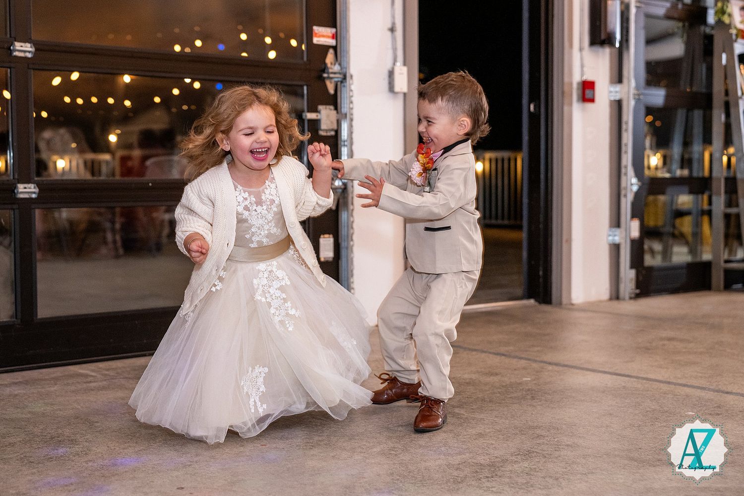 Dancing and celebrating in a spacious indoor venue with white decor and ambient lighting.