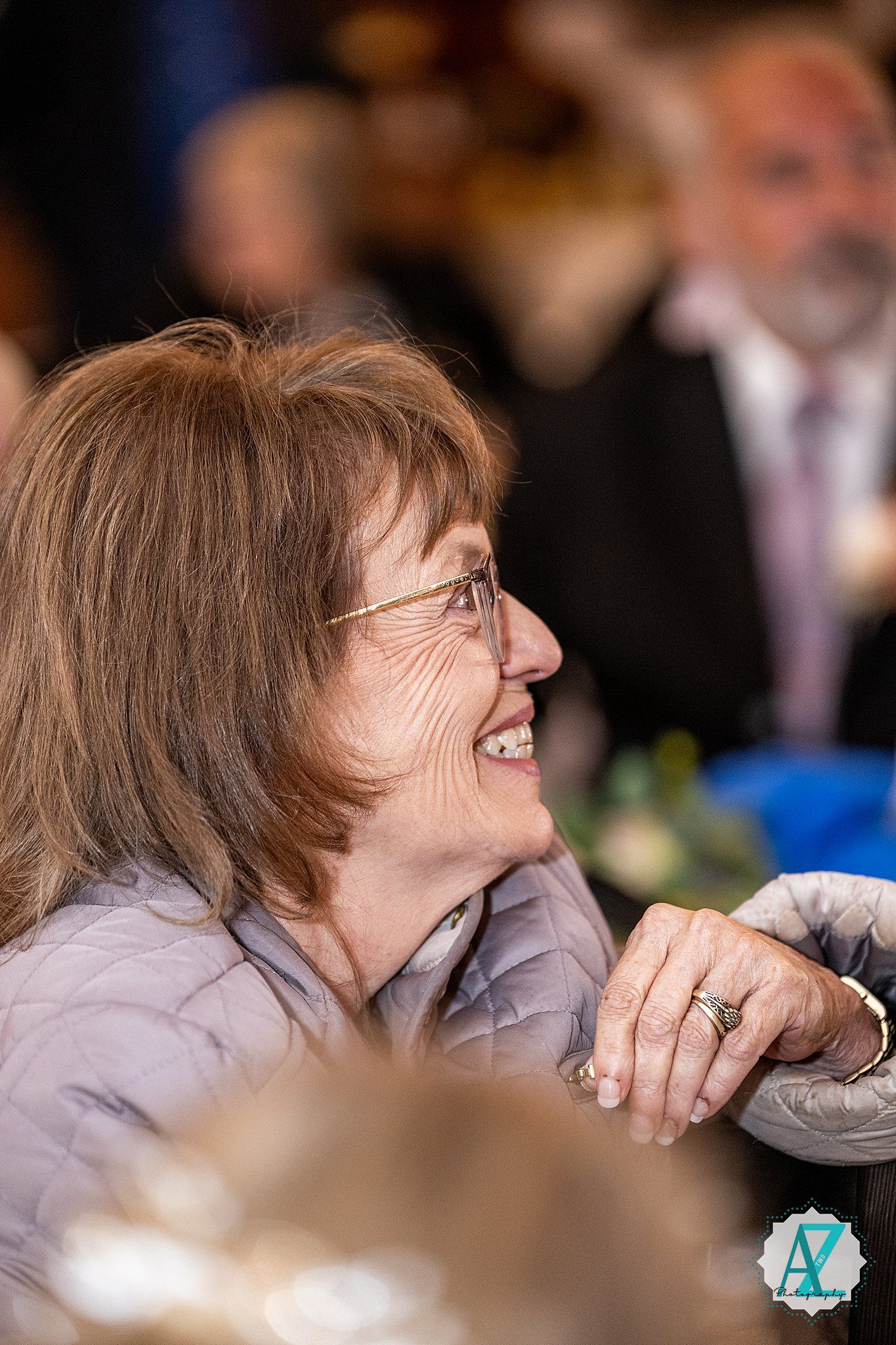 A guest enjoying candid moments during a wedding reception with soft focus lighting in the background.
