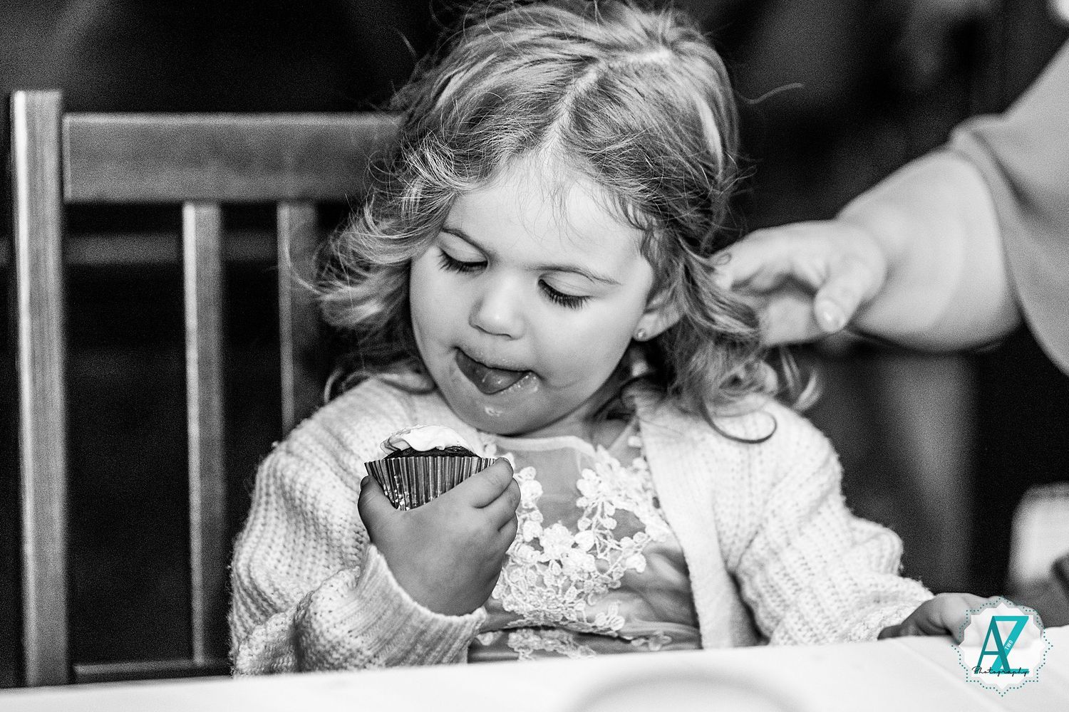 Black and white photo of children enjoying sweet treats at a wedding reception.