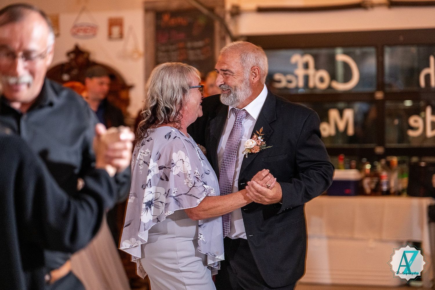 Elegant dancers perform traditional ballroom dance moves in a warmly lit indoor venue.