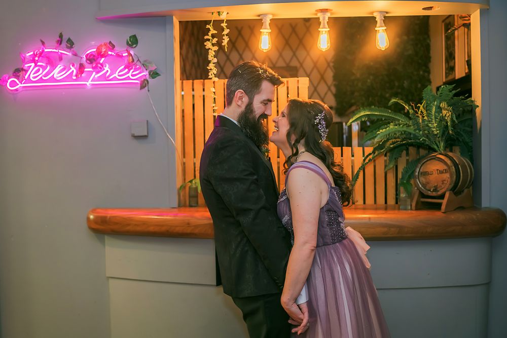 A dimly lit restaurant exterior with glowing pink neon signs and ambient lighting creates a warm evening atmosphere.