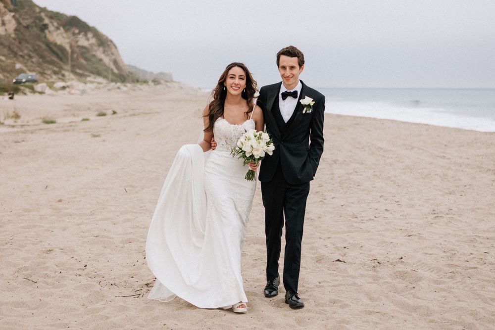 Dramatic Malibu film photography of the couple against the overcast cliffs of the Pacific.